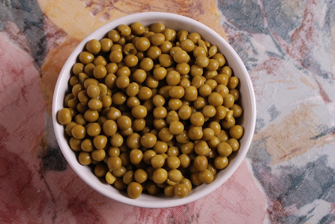 Piselli surgelati in una pentola sul fuoco, pronti per essere cotti secondo il trucco dell'articolo.
