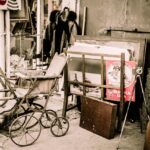 Collezione di oggetti vintage rari e preziosi su un tavolo, inclusi orologi e mobili.